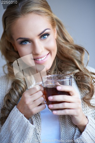 Image of Closeup portrait of a pretty woman holding a cup of tea
