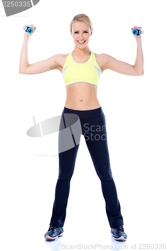 Image of Full lenght shoot of sporty female with dumbbell