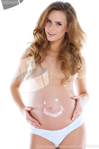 Image of Young pregnant woman with smile shape pained