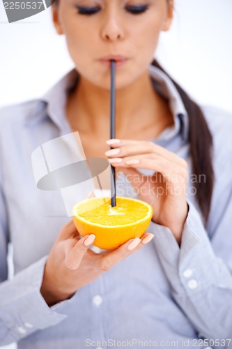 Image of Woman drinks orange juice through a straw