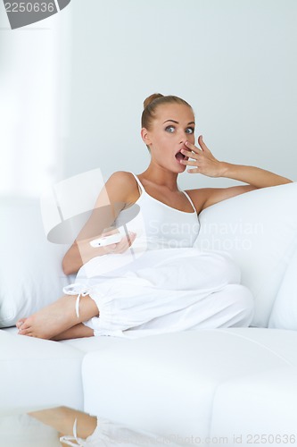 Image of Young woman is in shock while watching tv
