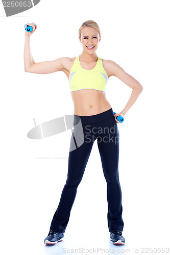 Image of Full lenght shoot of sporty female with dumbbell