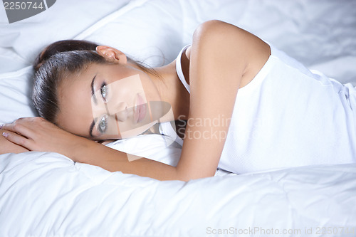Image of Beautiful woman is resting on white bed