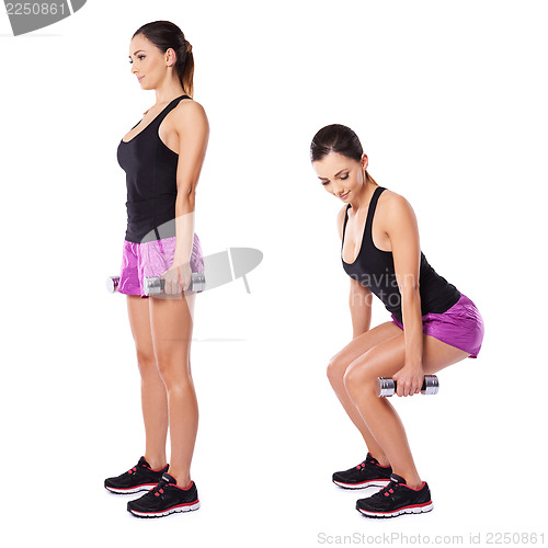 Image of Young woman working out with barbells