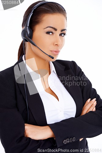 Image of Business woman standing with arms crossed, wearing headset