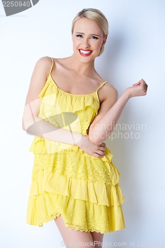 Image of Attractive blond young woman posing in yellow dress