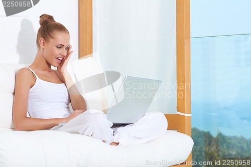 Image of Shocked woman laughing with laptop