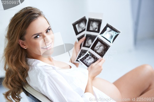 Image of Pregnant woman holding her USG pictures