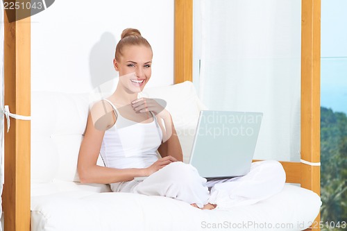 Image of Joyful woman laughing with laptop