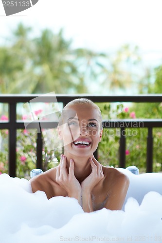 Image of Smiling woman enjoying a foamy bubble bath