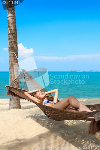 Image of Woman enjoying the serenity of a tropical beach