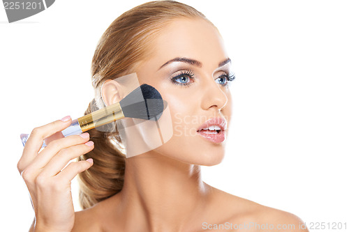 Image of Beautiful woman applying blusher