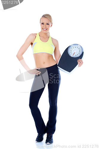 Image of Happy blond woman standing with weight scale