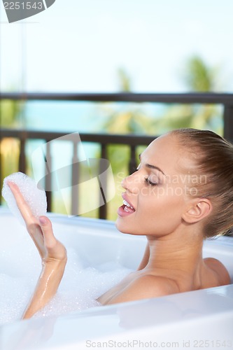 Image of Woman blowing bubbles in bubblebath