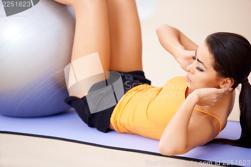 Image of Woman doing abdominal muscles with a fitness ball