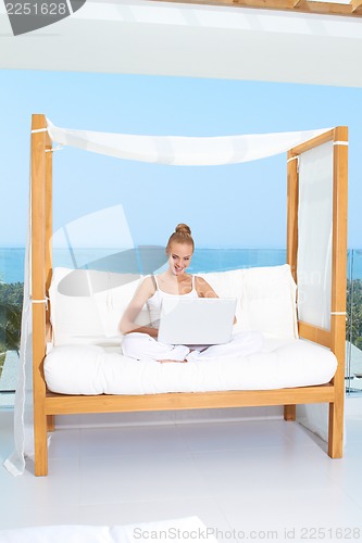 Image of Woman on canopied seat with laptop