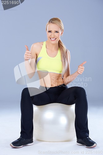 Image of Blond sporty woman sitting on fitness ball