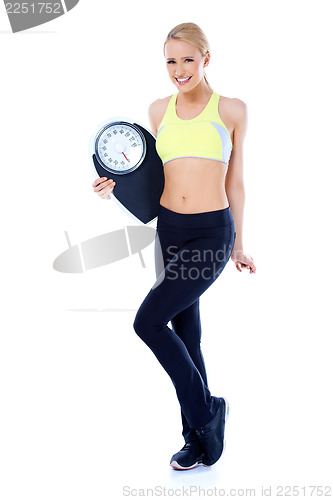 Image of Full body of blond sporty woman holding scale