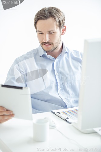 Image of Businessman checking his work at tablet