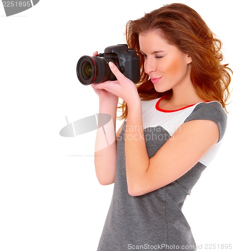 Image of Woman in gray dress wit digtal camera on white