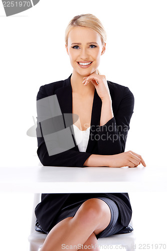 Image of Sexy blond business woman sitting in front of desk