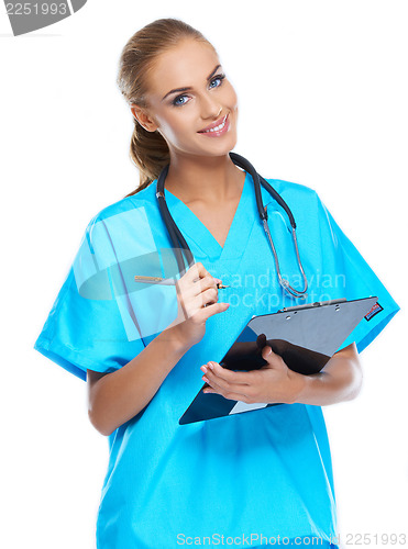 Image of Cute nurse looking at the camera and smiling with writingpad