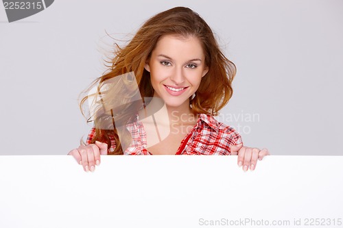Image of Young woman in casual clothing holding empty board