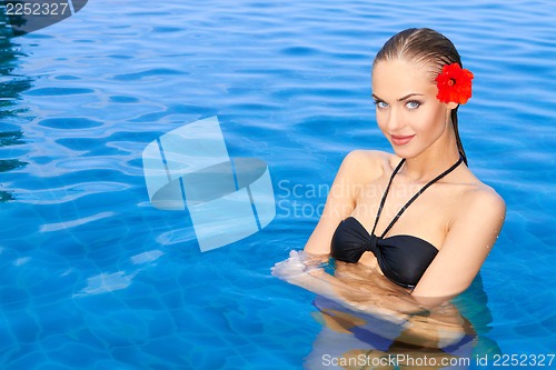 Image of Young woman standing in swimming pool