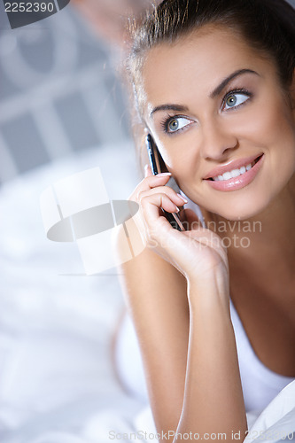 Image of Beautiful woman is resting on white bed