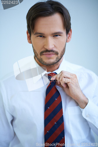 Image of Attractive man adjusting his tie