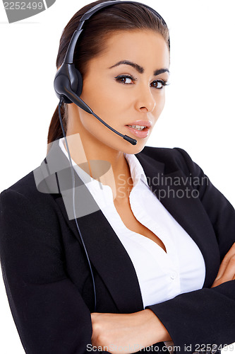 Image of Business woman standing with arms crossed, wearing headset