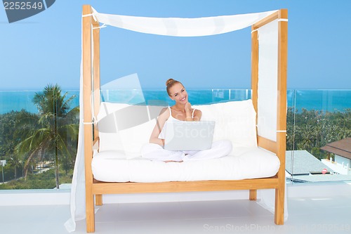 Image of Woman on canopied seat with laptop