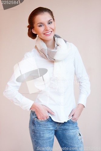 Image of Young sexy brunette woman in white shirt and blue jeans