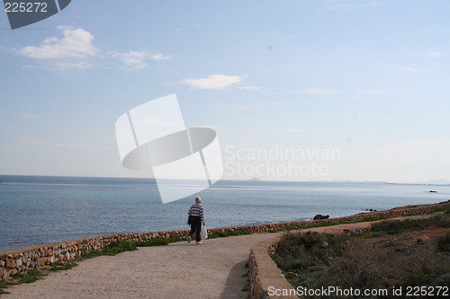 Image of Man on walk beside the sea