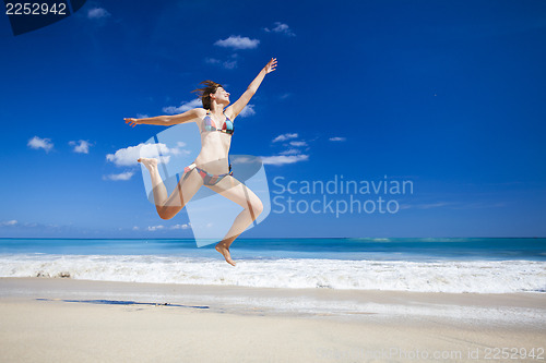 Image of Woman jumping on the beach