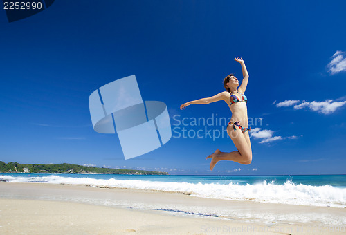 Image of Woman jumping on the beach