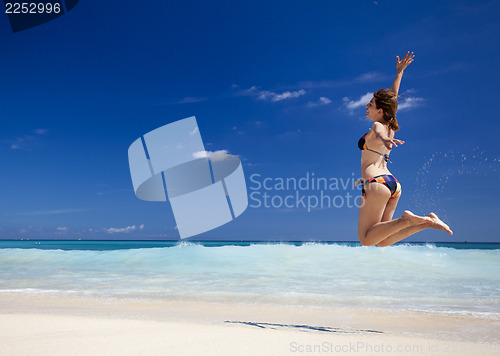 Image of Woman jumping on the beach