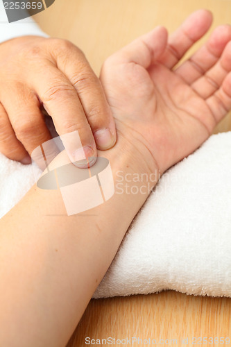 Image of Pulse diagnostic with hand on cushion