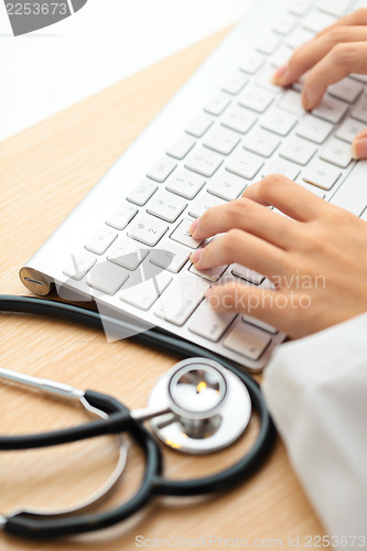 Image of Doctor typing on keyboard with stethoscope