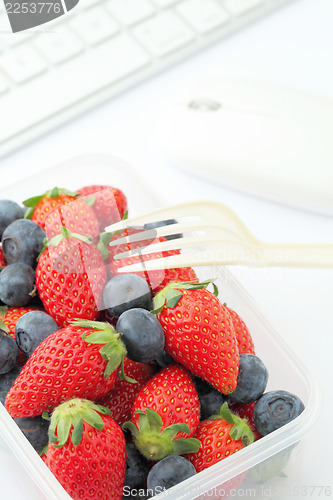 Image of Healthy lunch with strawberry and blueberry mix in office