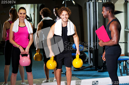 Image of Happy man and woman lifting kettlebell