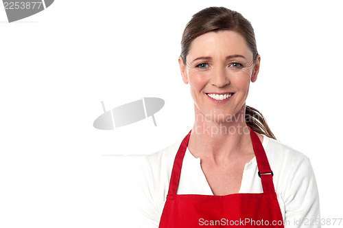 Image of Attractive female chef wearing red apron