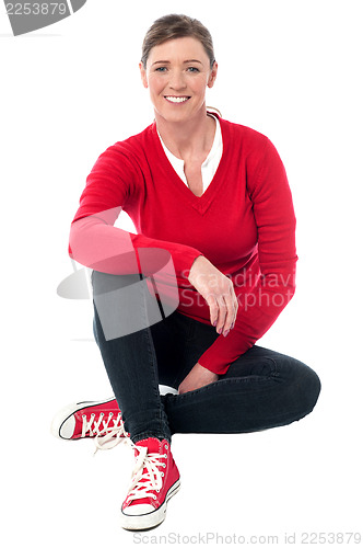 Image of Pretty woman in casuals sitting on the floor