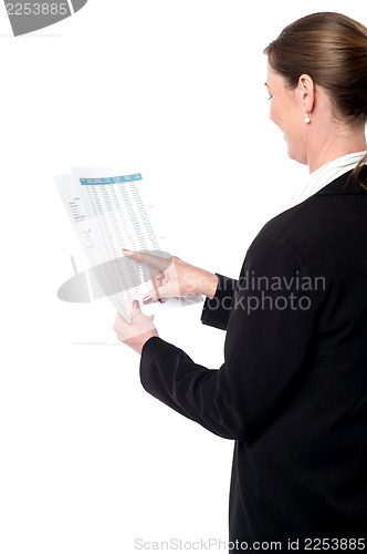 Image of Back pose of businesswoman reading reports