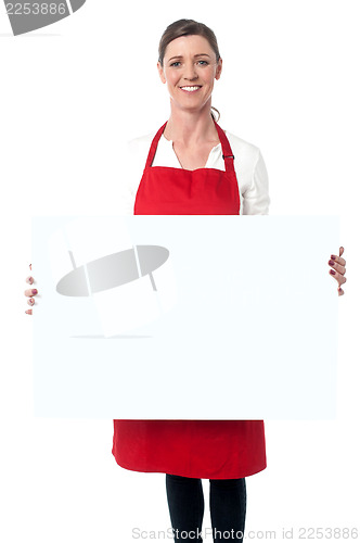 Image of Lady wearing apron holding white blank ad board