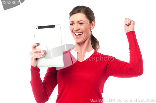 Image of Excited pretty woman holding touch pad