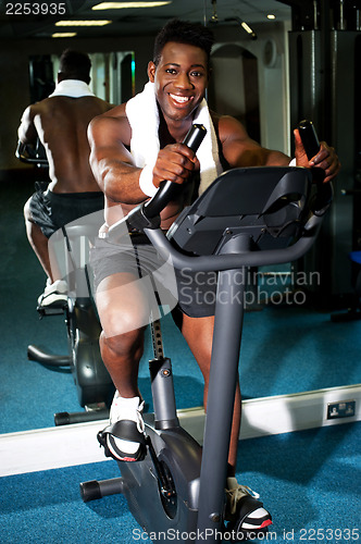 Image of Muscular man on excercise bike at the gym