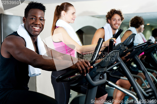 Image of Gym trainer exercising along with his trainees