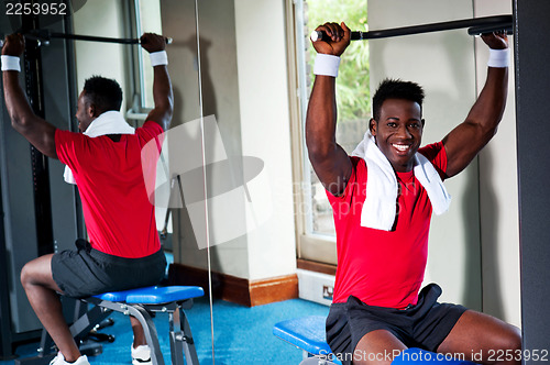 Image of Confident young african guy working out in gym