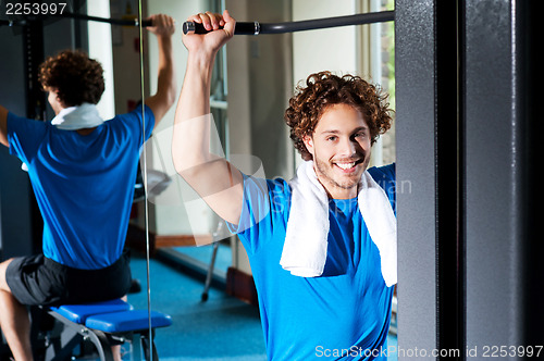 Image of Caucasian man sitting on bench and exercising